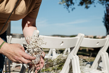 Anonymous decorating chairs at a wedding