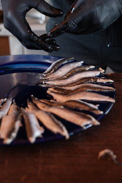 Anonymous cooker preparing a plate of anchovies