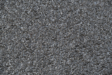 New wet asphalt texture. A frame filled with the textured surface of dry asphalt, showcasing the...