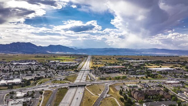 Highway traffic with mountains and rain clouds, aerial hyperlapse, Superior, Colorado, 4K