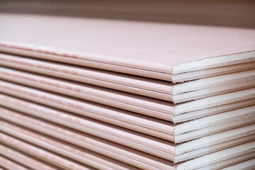 Stack of Plasterboard Fire Resistant gypsum. Drywall board cardboard surface Panel Type DF for indoor concrete walls prepared for construction