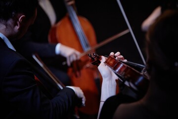 Close up on hand of unrecognizable orchestra musician playing violin in chamber quartet in studio, focus on hand and violin, copy space