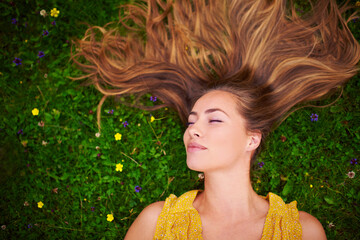 Woman, above and relax on grass in outdoor, travel and countryside nature for peace or calm. Female person, resting and field or meadow for sleeping, garden and flowers in park on holiday trip