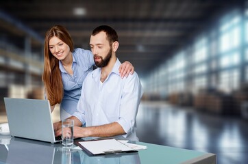 Male And Female Working In Workshop Using Laptop