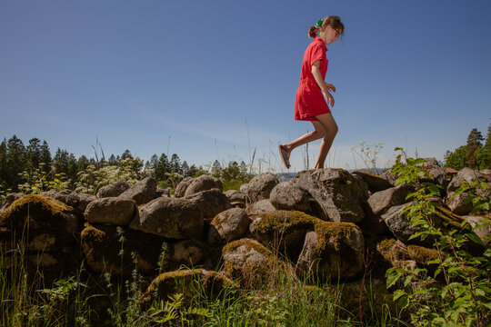 girl walking on a rock wall