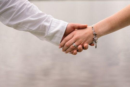 close up of bride and groom holding hands