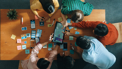 Top view of software developer team looking Ux Ui design for mobile phone interface from tablet...
