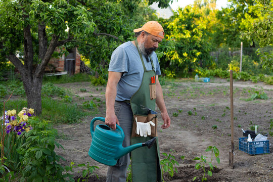 man with a watering can in the garden