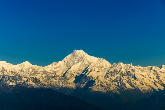 Beautiful first light from sunrise on Mount Kanchenjugha, Himalayan mountain range, Sikkim, India. Orange tint on the mountains at dawn