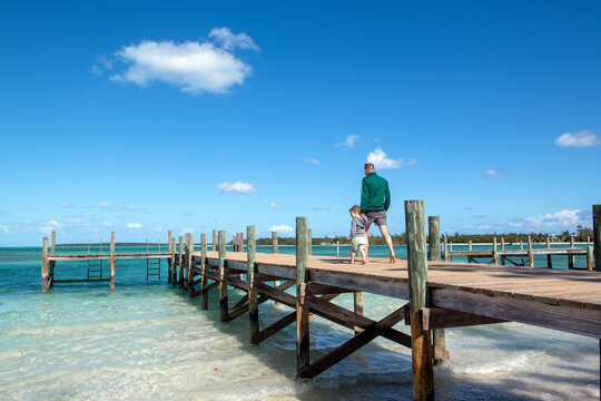 Father and son walk together on dock in Green Turtle Cay, Bahamas