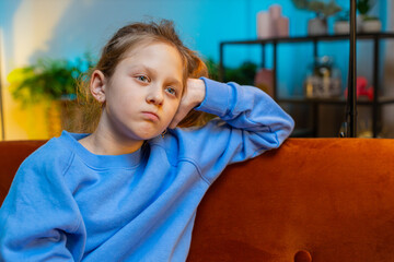 Sad lonely Caucasian child girl at home looks pensive thinks over life concerns or study test exam...