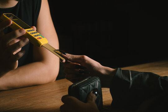 woman paying with card at bar