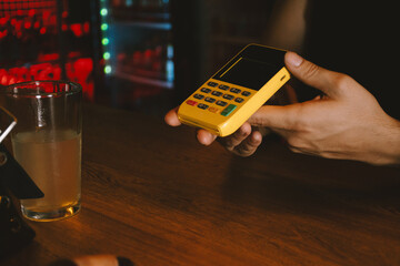 woman paying with card at bar