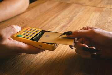 woman paying with card at bar