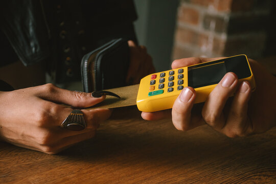 woman paying with card at bar