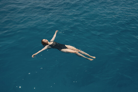 Woman resting on water with outstretched arms