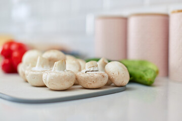 raw champignon on a cutting board on a white kitchen