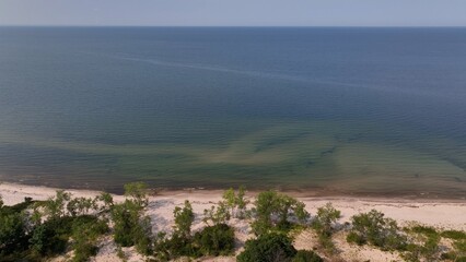 Beach front shoreline on Lake Ontario coast peaceful water blue sky morning light conservation nature preserve at Black Pond Beach in New York 