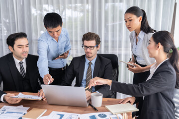 Diverse group of business analyst team analyzing financial data report paper on office table. Chart and graph dashboard by business intelligence analysis for strategic marketing planning Meticulous