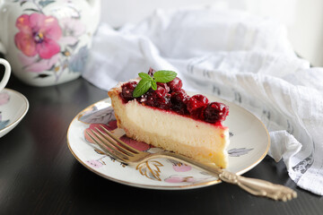 Appetizing portioned piece of cottage cheese tart and cherries on a porcelain plate. Tea party, morning, five o'clock