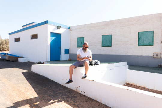 Tourist in a fishing town taking his phone