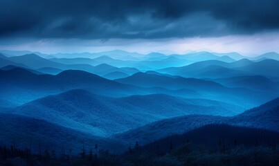 Fototapeta premium Dramatic stormy sky over layered blue mountains at nightfall
