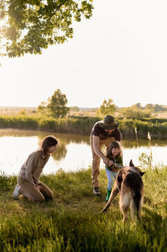 young family have a fun with a dog in nature