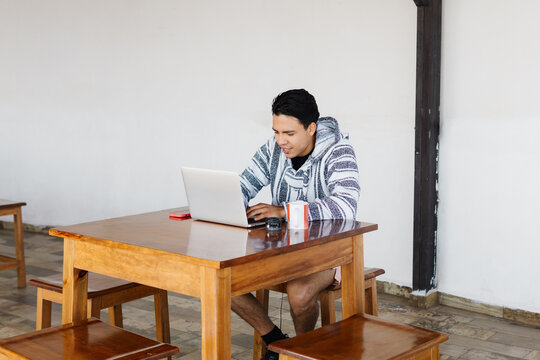 Latino man studying and using a computer.