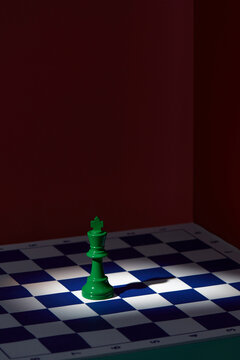Single Green Chess King On Chessboard Under Spotlight