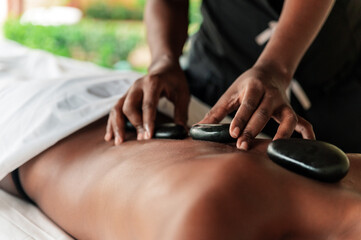 Hot stone massage therapy session at a spa