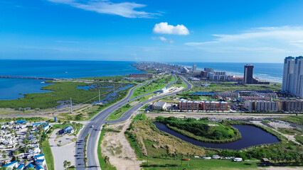 Beach RV park and camping site along State Park Road 100 near downtown South Padres Island, high-rise condos, beach-front hotels, white sandy beaches turquoise water, calm waves, aerial view