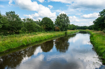 Green trees reflecting in the River Hase, Herzlake, Lower Saxony, Germany