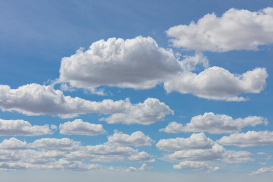 Cumulus clouds across vast blue sky