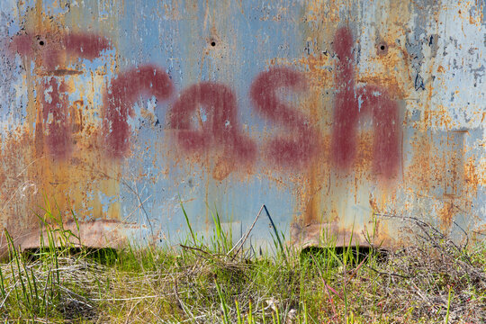 'Trash' spray painted on rusty metal 