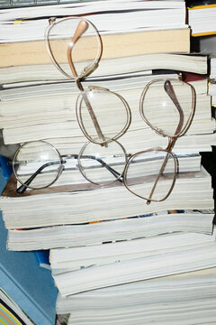 Stack of books and magazines and glasses with hard direct flashlight