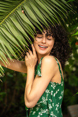 Exotic female model among green leaves