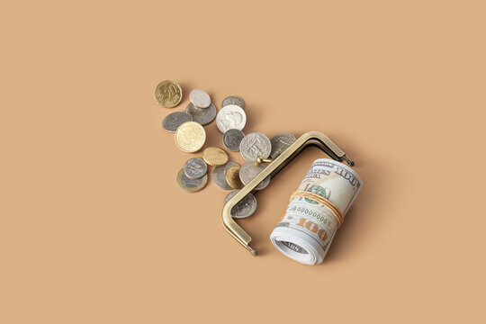 Pile of coins and roll of dollar banknotes imitating content of purse