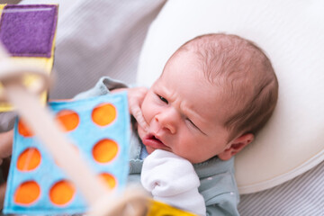 Newborn baby looking at contrast color mobile toys