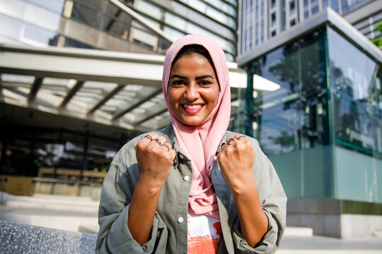 Portrait of cheerful woman clenching fists