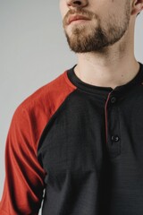 Obraz premium Portrait of a bearded man wearing a red and black shirt, looking directly at the camera