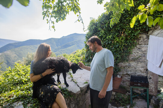 Couple and nanny-goat in the mountain garden