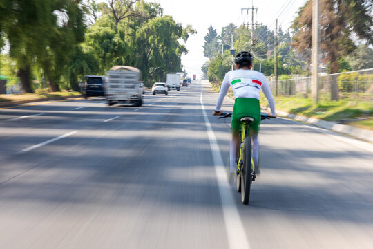 Motion blurred image of cyclist riding at high speed on a busy highway