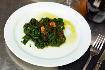 Catalan Spinach served on table with decanter of red wine