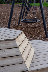 Fototapeta premium Close up of wood planks construction for sitting. Empty modern wooden bench. Brown ground. Tallinn, Estonia, Europe. July 2024