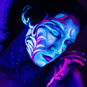 Person with Fluorescent Face Paint Under Blacklight