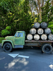 Fototapeta premium vintage car at winery with wine barrels, sunny day, winery visit, wine barrels
