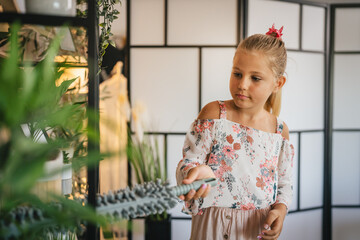 Young girl do chores clean and dust shelves with microfiber duster