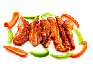 Sliced peppers and marinated spicy pork chops on white background. Asian style food. Uncooked meat for barbeque. High quality fine product