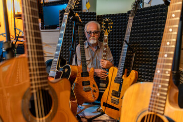 middle-aged professional guitarist posing in his home recording studio