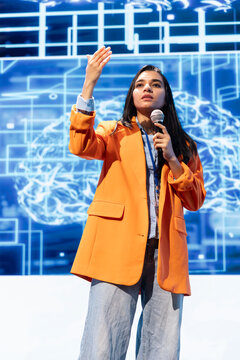 Technician presenting how AI technologies can bring businesses increased productivity during IT expo. Woman discussing about implementation of AI driven solutions during lecture
